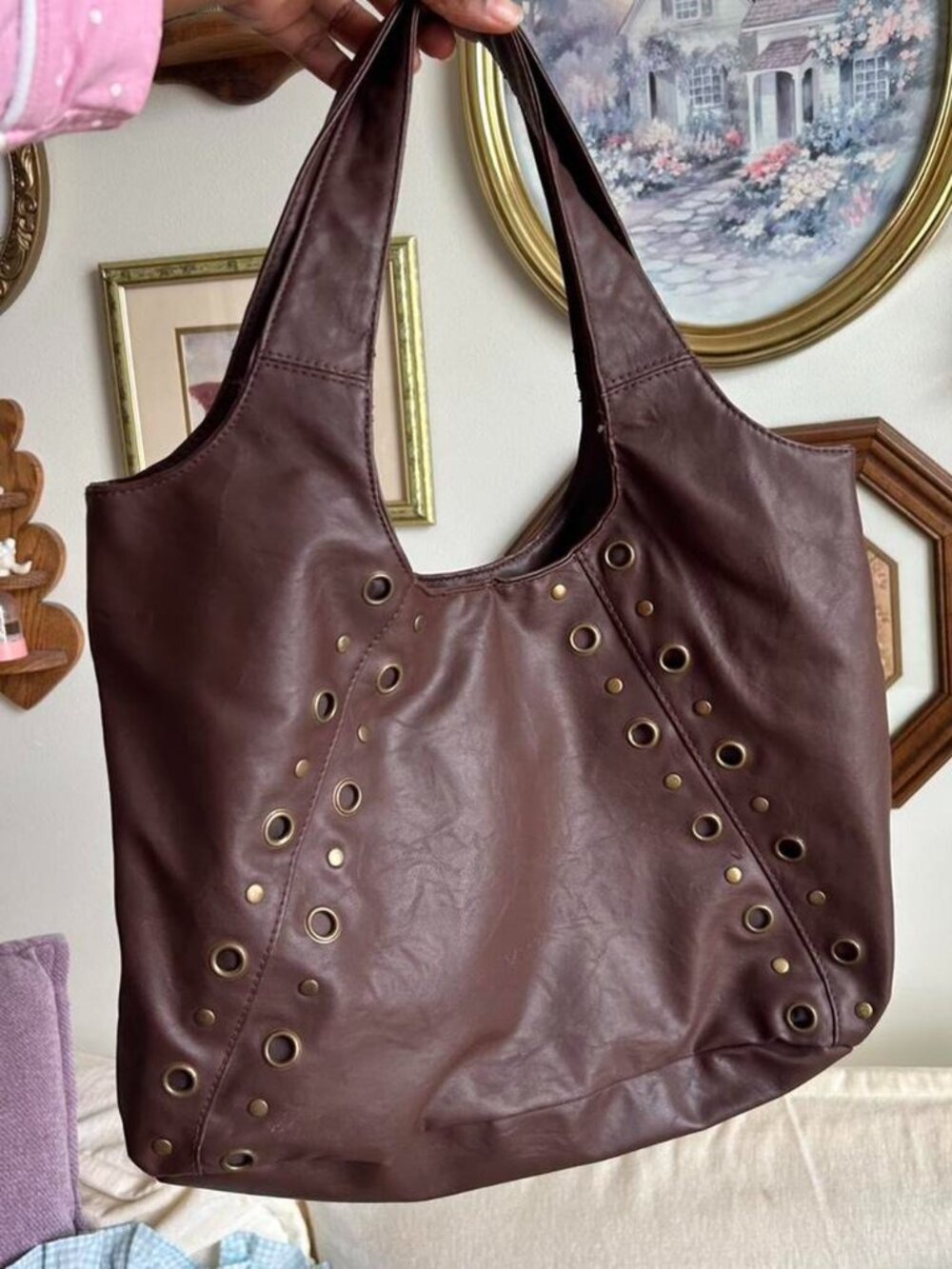 Brown leather tote bag with gold eyelet details